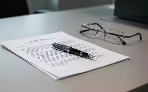 Ein Schreibtisch mit juristischen Unterlagen, einem Füllfederhalter und einer Lesebrille in einem Büro. - Foto: über boerse-global.de