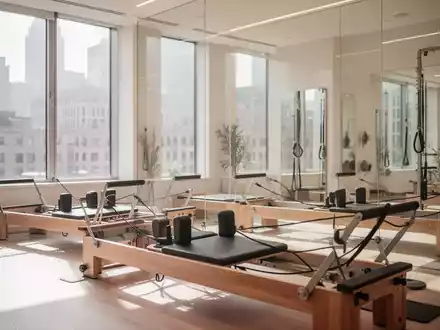 Modernes Pilates-Studio mit Reformer-Geräten in einem hellen, professionellen Trainingsraum. - Foto: über boerse-global.de