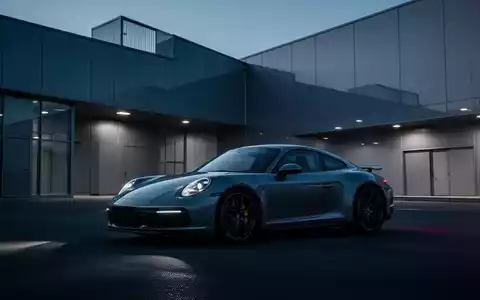 Moderner Porsche Sportwagen vor einer minimalistischen Industrieanlage während der Dämmerung. - Foto: über boerse-global.de