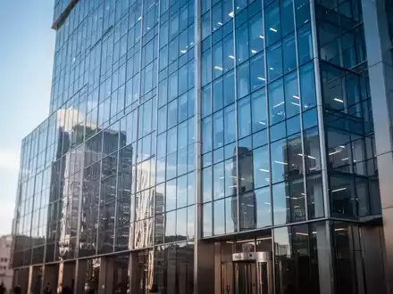 Modernes Bürogebäude in einem Finanzviertel mit spiegelnder Glasfassade bei hellem Tageslicht. - Foto: über boerse-global.de