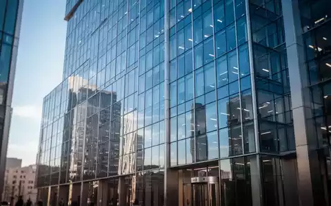 Modernes Bürogebäude in einem Finanzviertel mit spiegelnder Glasfassade bei hellem Tageslicht. - Foto: über boerse-global.de