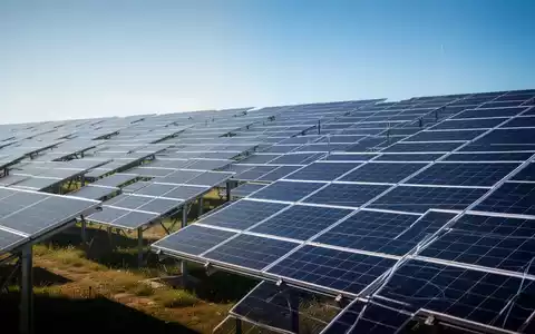 Reihen von Solarmodulen in einem Solarpark bei blauem Himmel. - Foto: über boerse-global.de