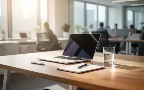Ein heller, moderner Büroarbeitsplatz mit Laptop und Notizbuch, der eine schrittweise Rückkehr in den Beruf symbolisiert. - Foto: über boerse-global.de