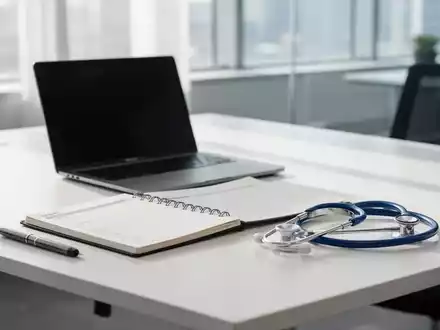 Ein moderner Schreibtisch mit Laptop und Stethoskop als Symbol für die Verbindung von Arbeit und medizinischer Genesung. - Foto: über boerse-global.de