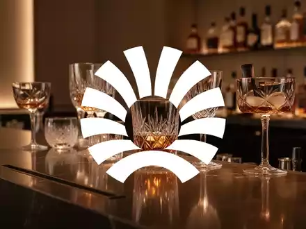 Elegantes, minimalistisches Bar-Ambiente mit warmem Licht und hochwertigen Gläsern, das die gehobene Getränkebranche symbolisiert. - Foto: über boerse-global.de