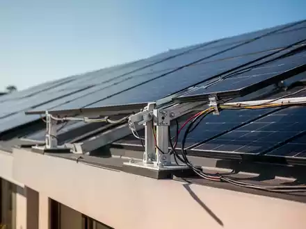 Nahaufnahme von modernen Photovoltaik-Solarpaneelen auf einem Hausdach bei hellem Tageslicht. - Foto: über boerse-global.de