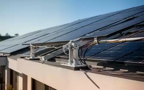 Nahaufnahme von modernen Photovoltaik-Solarpaneelen auf einem Hausdach bei hellem Tageslicht. - Foto: über boerse-global.de