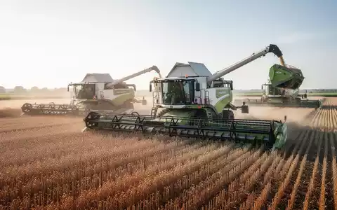 Ein moderner landwirtschaftlicher Großbetrieb mit automatisierten Maschinen bei der Ernte auf einem sonnigen Feld. - Foto: über boerse-global.de