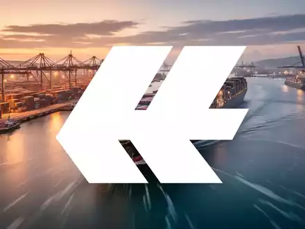 Ein modernes Containerterminal in der Abenddämmerung mit gestapelten Containern und einem einlaufenden Frachtschiff. - Foto: über boerse-global.de