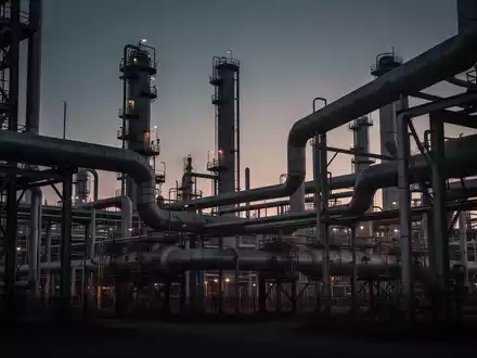 Industrielle Ölraffinerie bei Dämmerung mit Fokus auf Pipelines und Stahlstrukturen. - Foto: über boerse-global.de