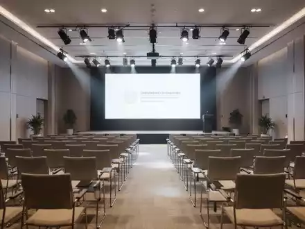 Moderner Konferenzsaal für eine Hauptversammlung mit Blick auf eine Bühne und Sitzreihen. - Foto: über boerse-global.de