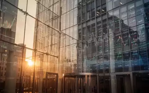 Modernes Börsengebäude mit spiegelnden Glasfronten und angedeuteten Finanzgrafiken bei goldenem Licht. - Foto: über boerse-global.de