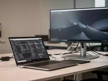 Moderner, ergonomisch gestalteter Büroarbeitsplatz mit Laptop, großem Monitor und aufgeräumter technischer Ausstattung. - Foto: über boerse-global.de