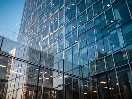 Moderne Glasfassade eines BĂŒrogebĂ€udes bei Tageslicht als Symbol fĂŒr rechtliche Aufsicht und Transparenz. - Foto: ĂŒber boerse-global.de