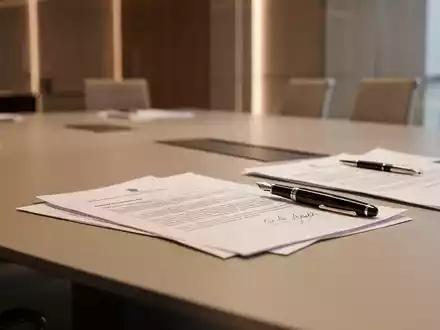Ein moderner Konferenztisch in einem Büro mit Unterlagen und einem Füllfederhalter als Symbol für arbeitsrechtliche Verhandlungen. - Foto: über boerse-global.de