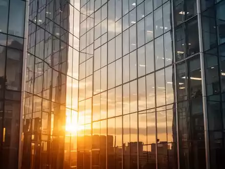 Moderne Glasfassade eines Bürogebäudes im goldenen Licht als Symbol für wirtschaftliches Wachstum. - Foto: über boerse-global.de