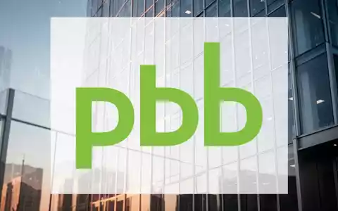Moderne Glasfassade eines Bürogebäudes bei Tageslicht als Symbol für Immobilienfinanzierung und Stabilität. - Foto: über boerse-global.de