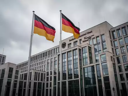 Das Bundesgesundheitsministerium in Berlin an einem bewölkten Tag mit der deutschen Flagge vor dem Gebäude. - Foto: über boerse-global.de