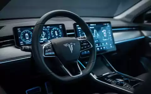 Modernes Armaturenbrett eines Elektroautos mit digitalen Anzeigen und leuchtendem Touchscreen in einer dunklen Umgebung. - Foto: über boerse-global.de