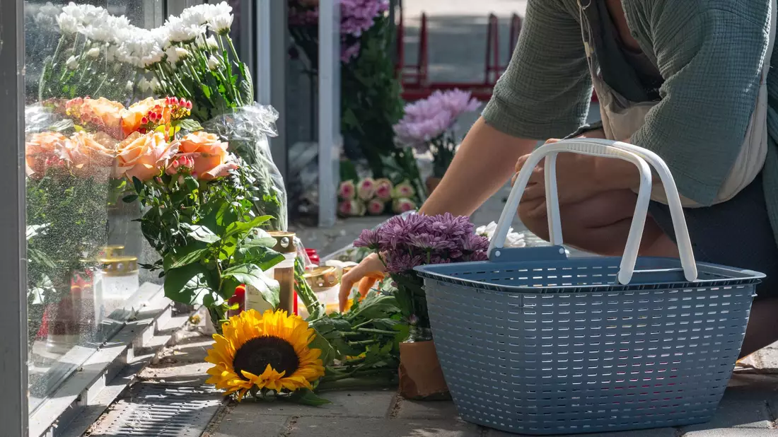 Am Tag nach dem Angriff legten Menschen Blumen am Tatort nieder. - Bild: Armin Weigel/dpa