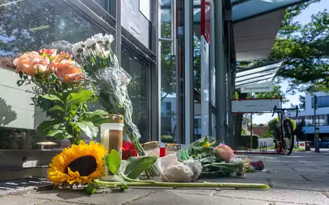 Menschen legten nach dem tödlichen Angriff Blumen und Kerzen vor der Filiale ab. - Foto: Armin Weigel/dpa