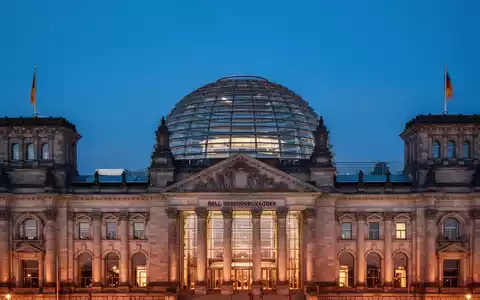Das Berliner Reichstagsgebäude bei Dämmerung als Symbol für politische Veränderungen in der Bundesregierung. - Foto: über boerse-global.de