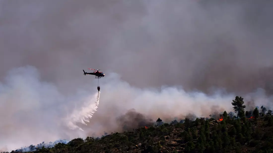 Starker Wind erschwert in Spanien die Bekämpfung der Waldbrände. - Bild: Manu Fernandez/AP/dpa