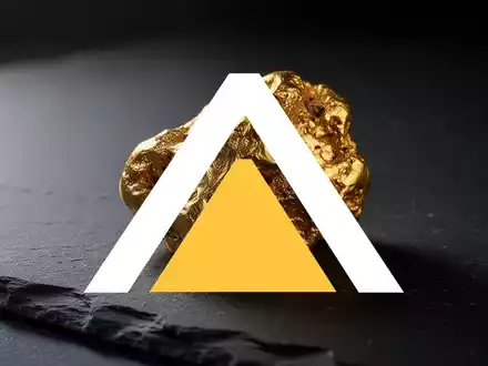 Ein goldener Nugget auf einem dunklen, strukturierten Steinuntergrund in einer professionellen, atmosphärischen Aufnahme. - Foto: über boerse-global.de