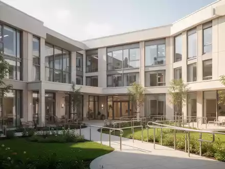 Modernes Pflegeheim mit ansprechender Architektur und barrierefreien Außenanlagen bei Tageslicht. - Foto: über boerse-global.de