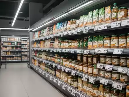 Ein aufgeräumtes Supermarktregal mit Preisschildern in einer hellen, professionellen Ladenumgebung. - Foto: über boerse-global.de