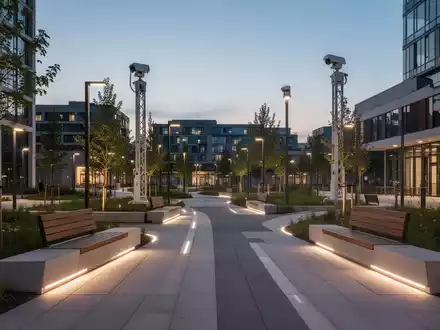 Modern gestalteter Stadtpark mit klarer Sicht, neuer Beleuchtung und einem mobilen Überwachungsturm in der Dämmerung. - Foto: über boerse-global.de