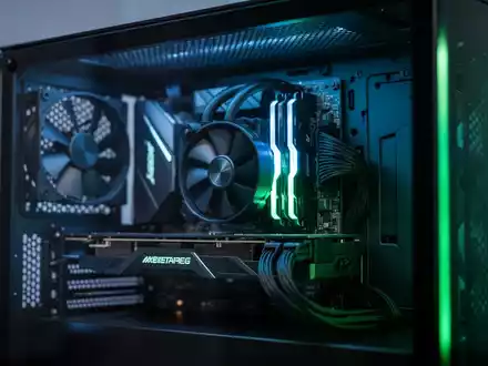 Hochleistungs-Gaming-PC-Innenleben mit blauer und grüner Ambientebeleuchtung, Fokus auf Grafikkarten-Hardware. - Foto: über boerse-global.de