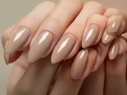 Gepflegte Fingernägel in mandelförmiger, kurzer Länge mit dezentem, glänzendem Beige-Pink-Nagellack. - Foto: über boerse-global.de
