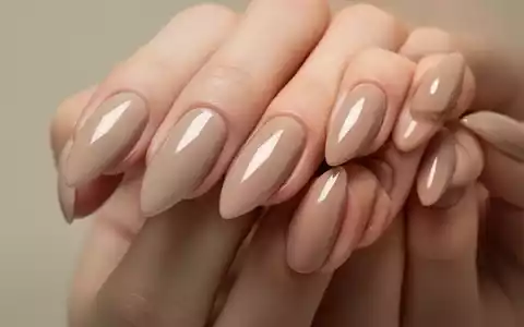 Gepflegte Fingernägel in mandelförmiger, kurzer Länge mit dezentem, glänzendem Beige-Pink-Nagellack. - Foto: über boerse-global.de