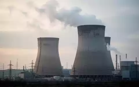 Ein Kühlturm eines Kernkraftwerks vor einem bewölkten Himmel, der die Marktunsicherheit bei Uran-Investitionen symbolisiert. - Foto: über boerse-global.de
