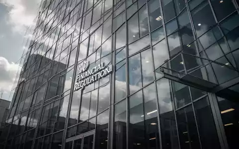 Moderne Glasfassade eines Bürogebäudes unter bewölktem Himmel, symbolisiert Finanzregulierung und Unternehmenskontrolle. - Foto: über boerse-global.de