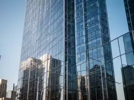 Moderne Glasfassade eines Wolkenkratzers im Finanzviertel bei klarem Himmel. - Foto: über boerse-global.de