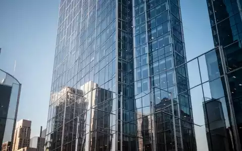 Moderne Glasfassade eines Wolkenkratzers im Finanzviertel bei klarem Himmel. - Foto: über boerse-global.de
