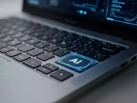 Nahaufnahme einer modernen Laptop-Tastatur mit Fokus auf eine dedizierte KI-Taste in einer professionellen Büroumgebung. - Foto: über boerse-global.de
