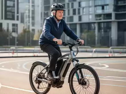 Ein älterer Mensch mit Helm fährt konzentriert auf einem modernen E-Bike während eines Sicherheitstrainings. - Foto: über boerse-global.de