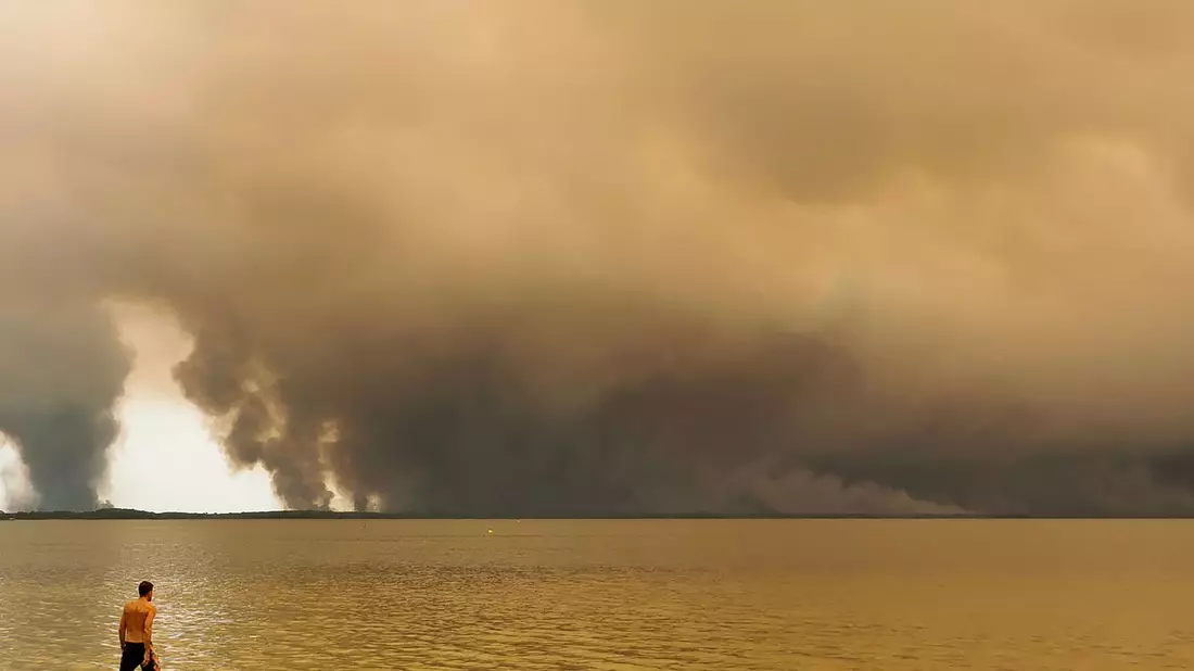 Strandbesuch vor Rauchwolken in Lacanau im Südwesten Frankreichs. - Bild: Maximilien Lamy/AFP/dpa