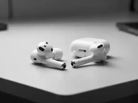 Nahaufnahme moderner Apple AirPods auf einem minimalistischen Schreibtisch bei eleganter Studiobeleuchtung. - Foto: über boerse-global.de