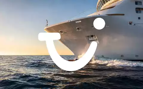 Ein modernes Kreuzfahrtschiff bei Sonnenaufgang auf dem offenen Ozean als Symbol für die Reisebranche. - Foto: über boerse-global.de