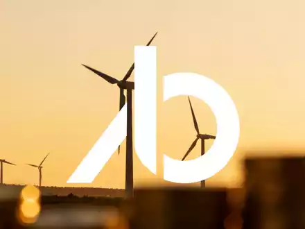 Moderne Windkraftanlagen in einer weitläufigen Landschaft bei Sonnenuntergang als Symbol für Energieinvestitionen. - Foto: über boerse-global.de
