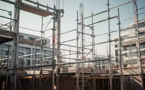 Moderne Baustelle im deutschen Bauhauptgewerbe mit Stahlgerüsten und architektonischen Strukturen bei klarem Tageslicht. - Foto: über boerse-global.de