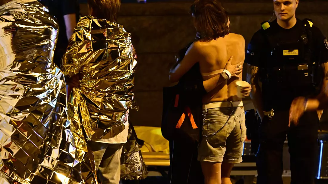 Menschen hüllen sich in Rettungsdecken und umarmen sich. - Bild: Fabian Sommer/dpa