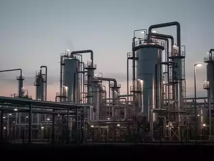 Moderne Chemieanlage bei Dämmerung mit Fokus auf Industrieanlagen und Rohrsysteme vor einem bewölkten Himmel. - Foto: über boerse-global.de