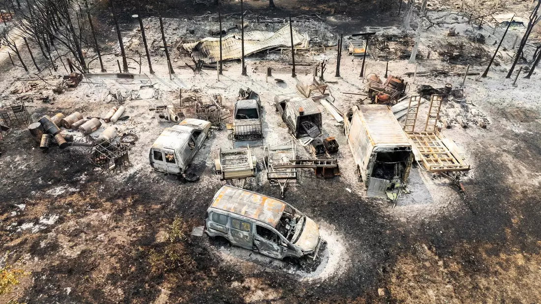 Aus der Luft sind ausgebrannte Autos nach einem Waldbrand zu sehen. - Bild: Florian Plaucheur/AFP/dpa
