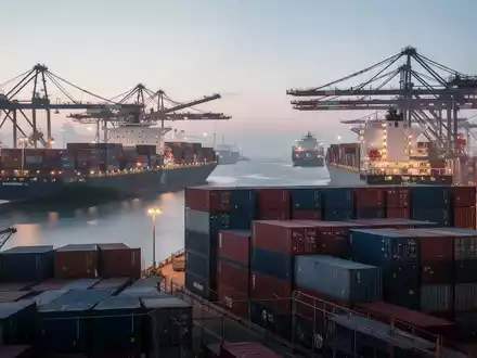 Ein moderner Seehafen mit Containerschiffen bei Dämmerung, der den internationalen Warenverkehr symbolisiert. - Foto: über boerse-global.de
