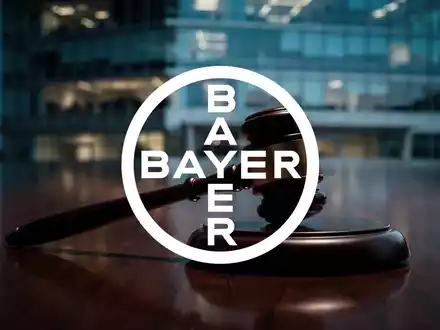Ein hölzerner Auktionshammer auf einem dunklen Tisch vor einem unscharfen Bürogebäude bei Dämmerung. - Foto: über boerse-global.de
